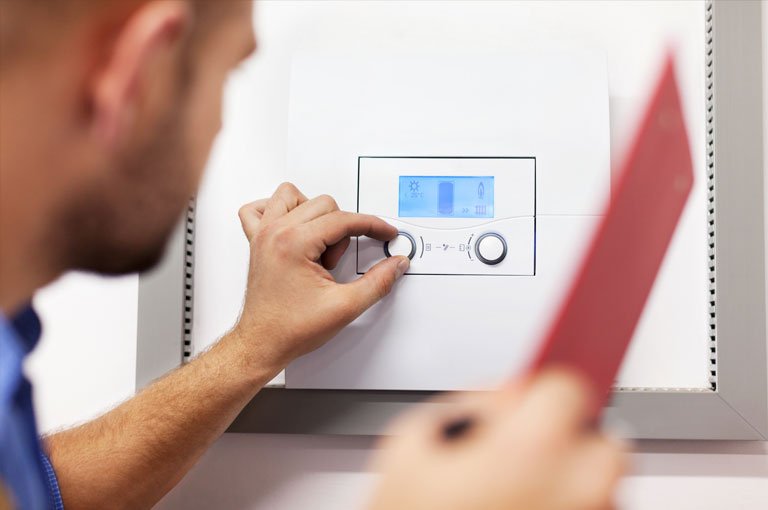 Engineer Performing a Gas Safety Check On A Boiler