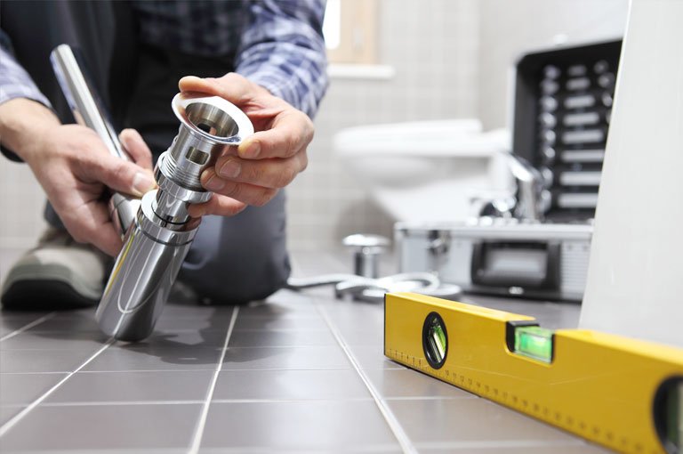 Plumber working with parts on floor